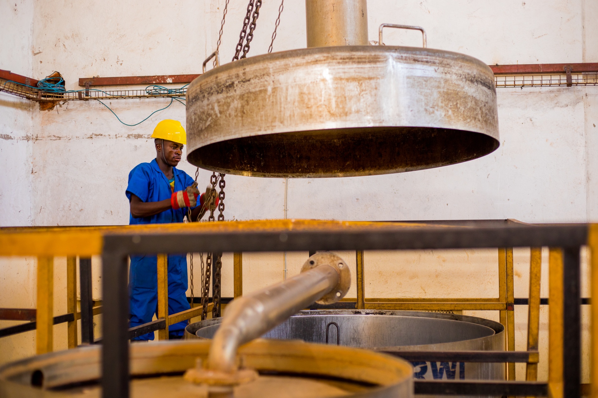 A Rugofarm operator working the stainless steel distillation vats at the Cibitoke facility