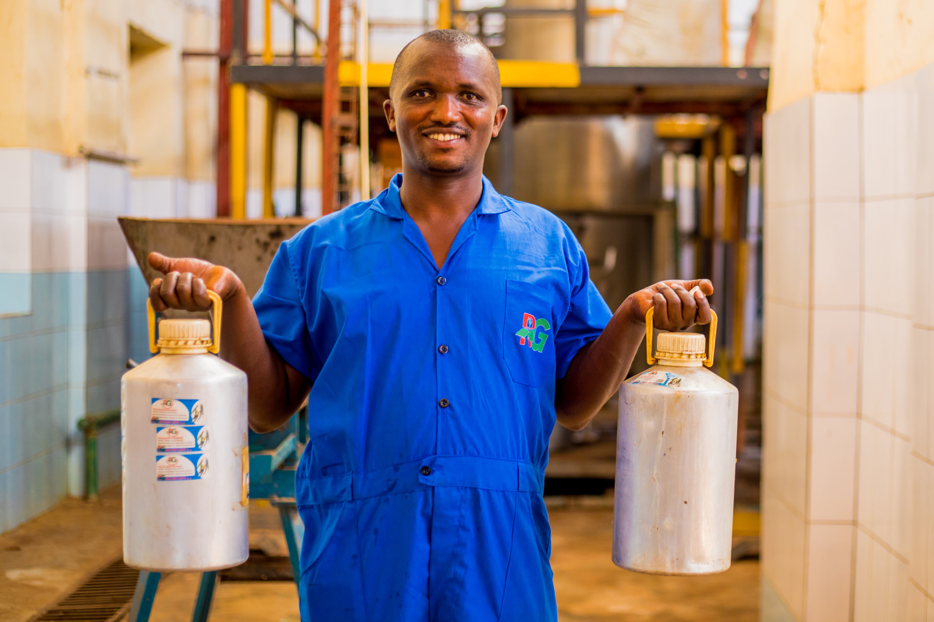 Rugofarm distillery worker holding freshly filled patchouli oil jars